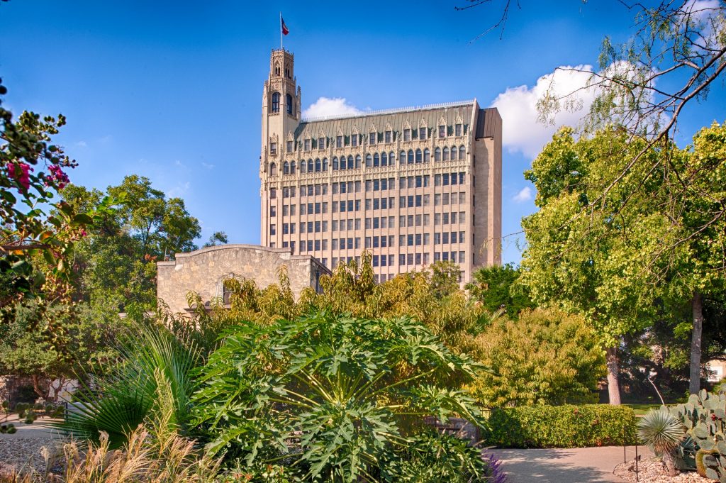 Exterior view of The Emily Morgan hotel with the Alamo in the foreground.