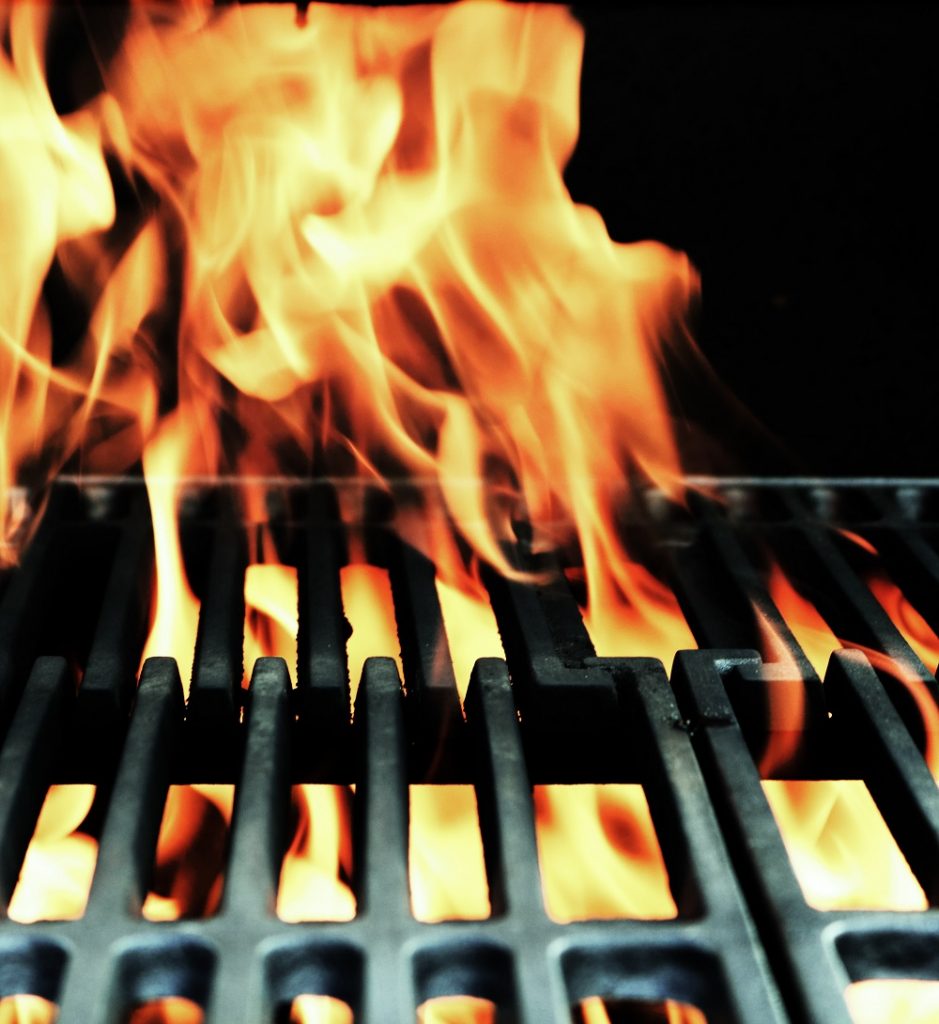 Closeup of flames through a grill.
