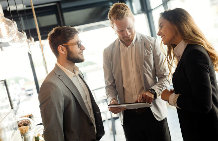 Two men and a woman discussing corporate events.