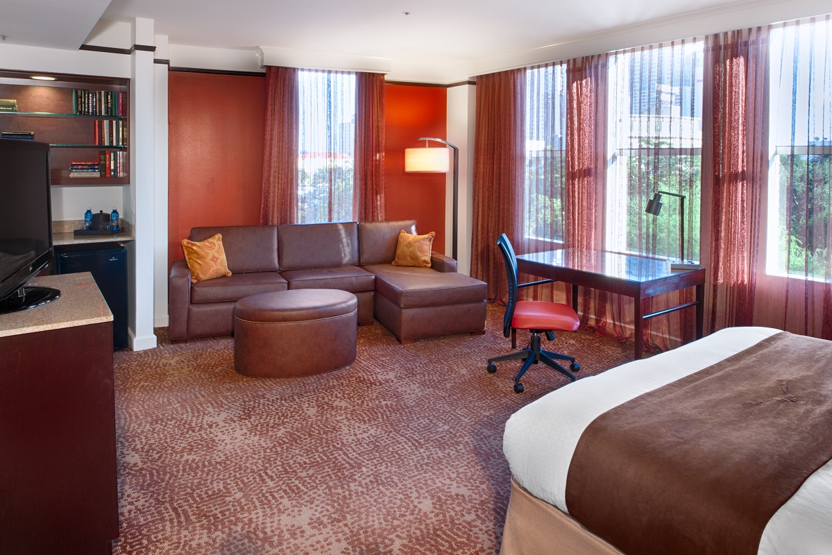 The spacious King Deluxe Room, featuring a king bed, comfortable sleeper sofa, executive work desk, and beautiful views of San Antonio.