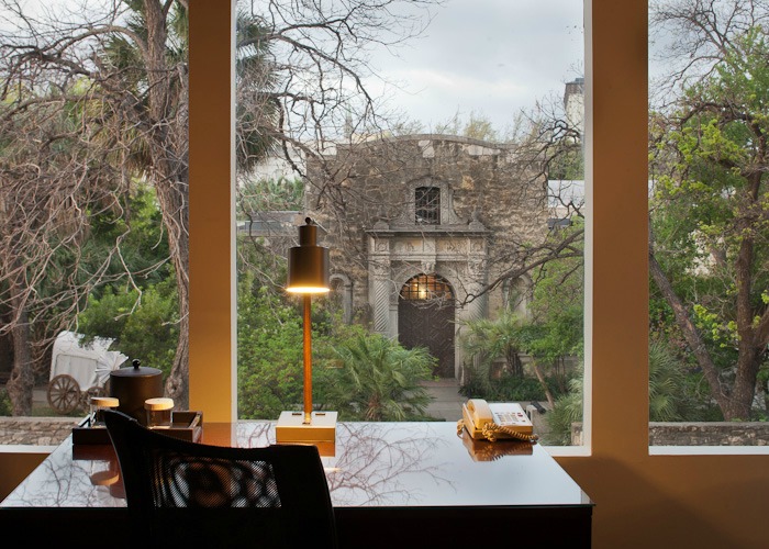 A guestroom at the Emily Morgan with a desk and view of the Alamo out the window.