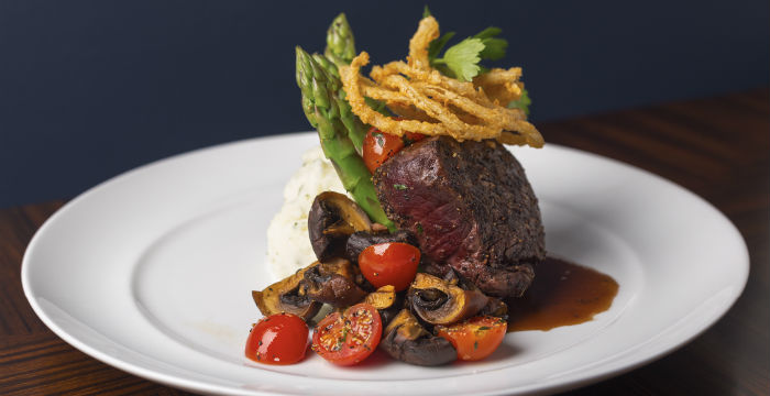 Steak, mashed potatoes, asparagus and other vegetables.