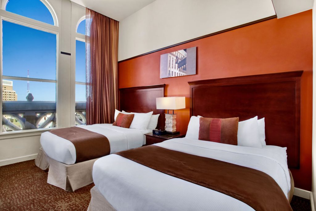 Guestroom at the Emily Morgan Hotel featuring two queen beds and a view of the Alamo.