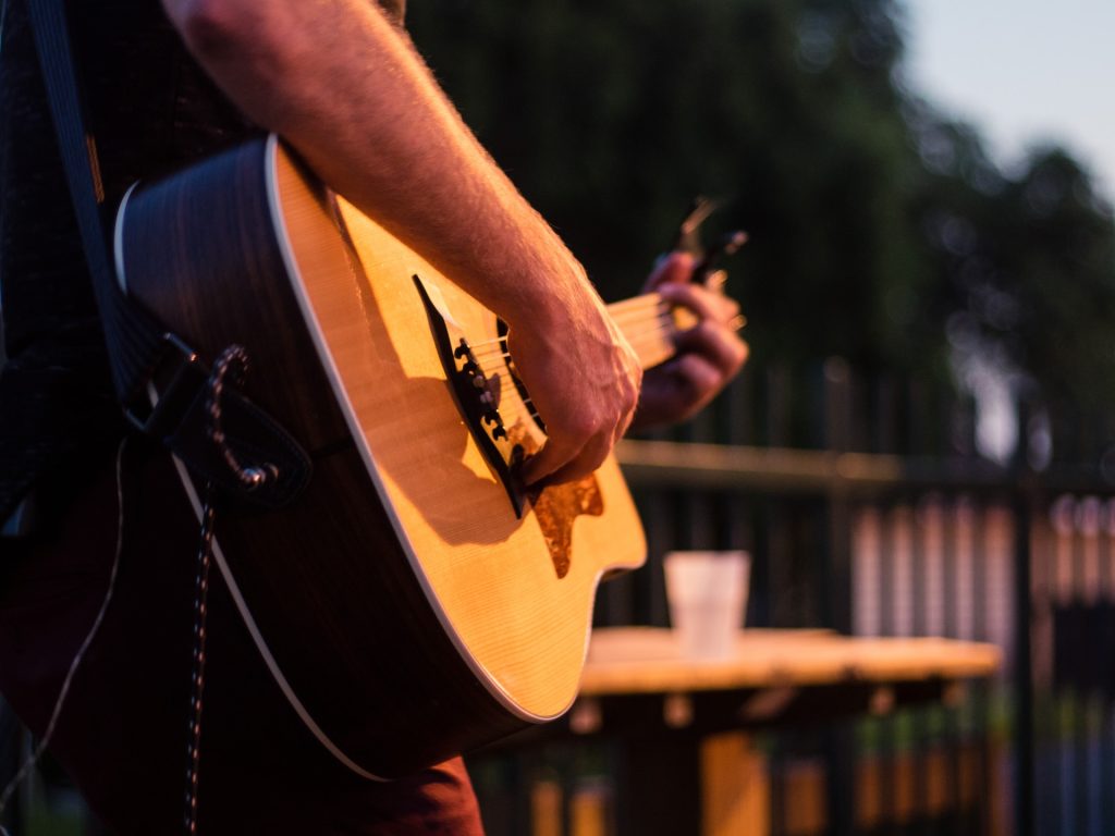 Close up of a guitarist strumming a guitar.