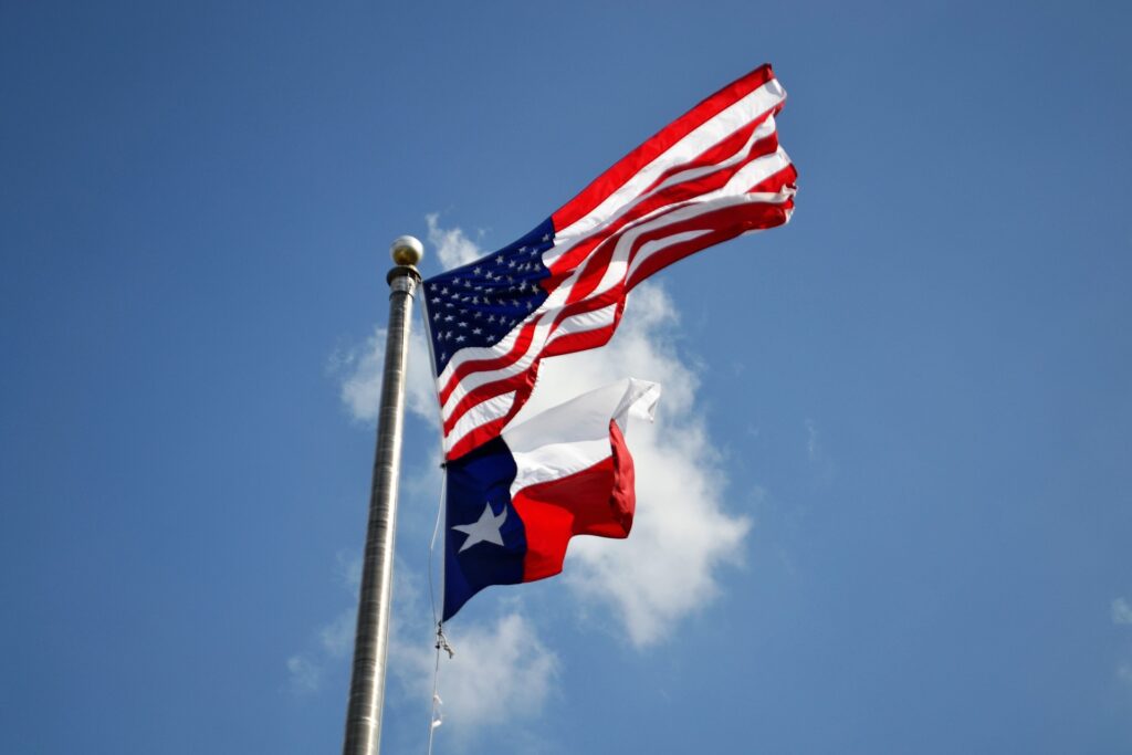 US and Texas flags flapping in the breeze.